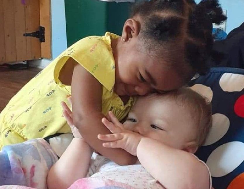 Two toddlers sharing a hug